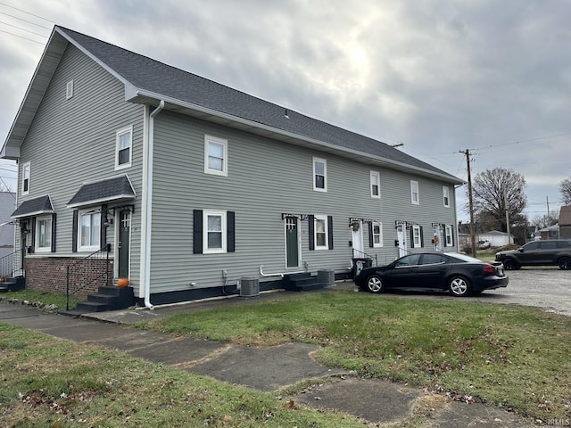 view of front of home featuring central air condition unit and a front yard