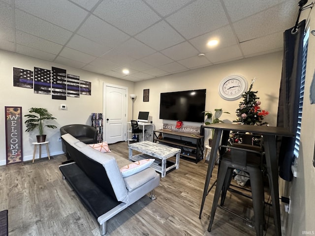 living room featuring hardwood / wood-style floors and a drop ceiling