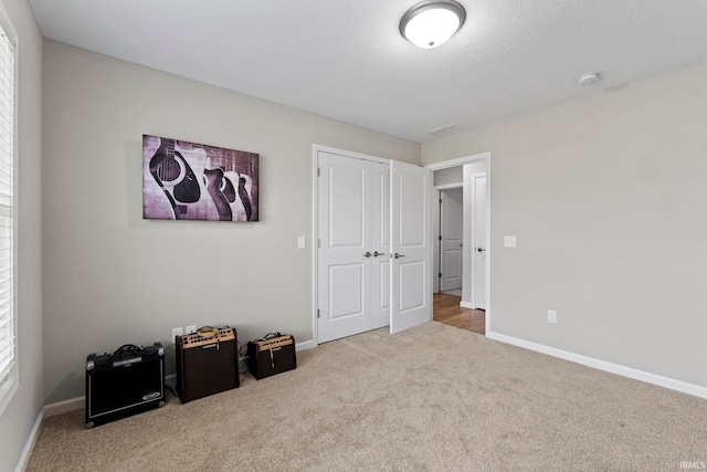 carpeted bedroom featuring a closet and a textured ceiling