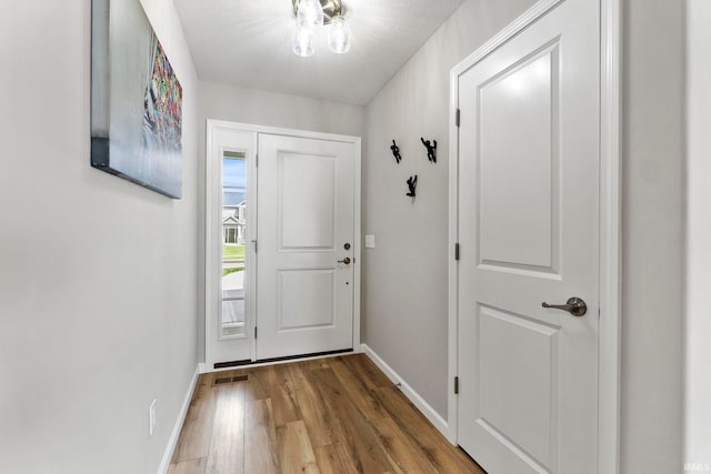 doorway with hardwood / wood-style flooring and a textured ceiling