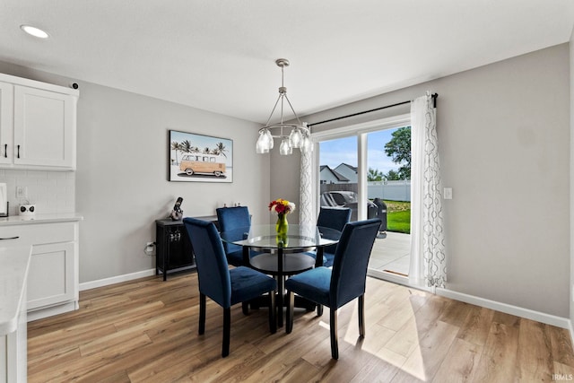 dining space with a chandelier and light hardwood / wood-style floors