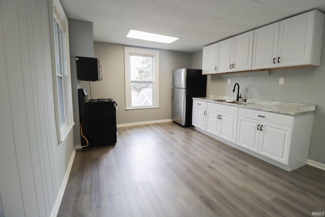 kitchen with sink, white cabinetry, and light hardwood / wood-style flooring