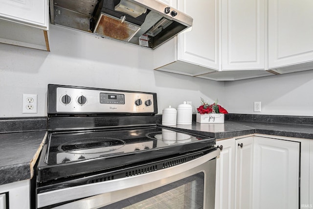 kitchen featuring electric range, white cabinets, and ventilation hood