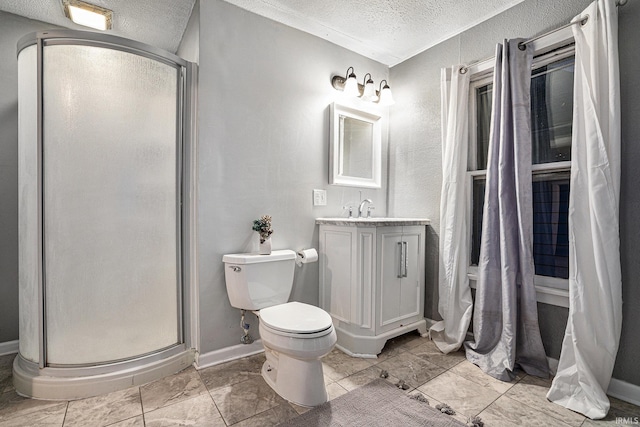 bathroom featuring vanity, a textured ceiling, toilet, and a shower with door