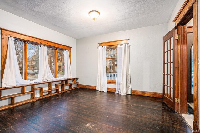 unfurnished room with dark hardwood / wood-style floors and a textured ceiling