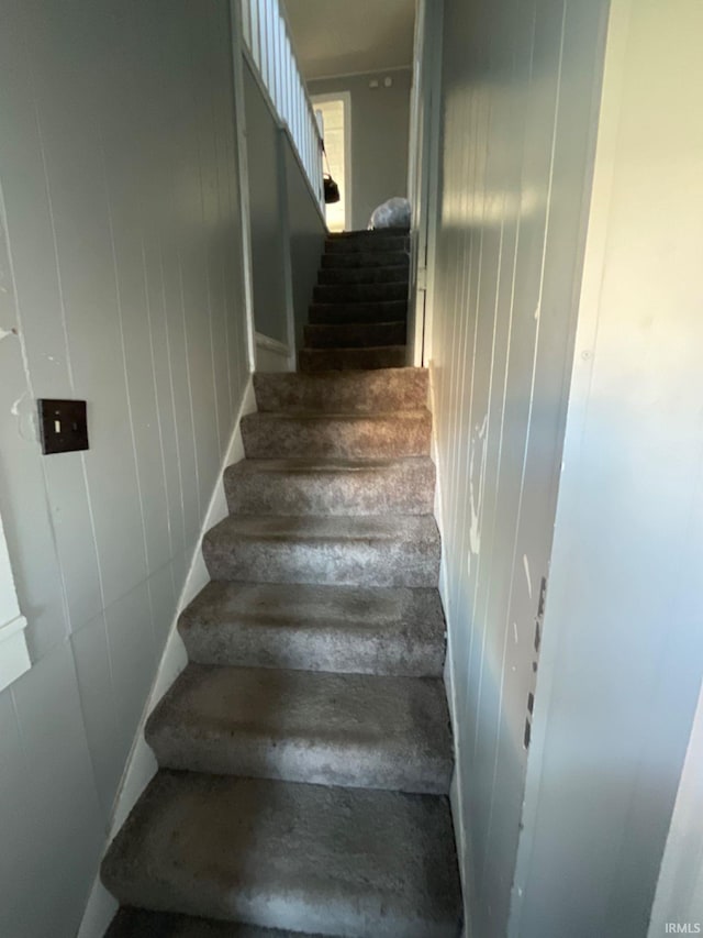 stairs featuring wooden walls