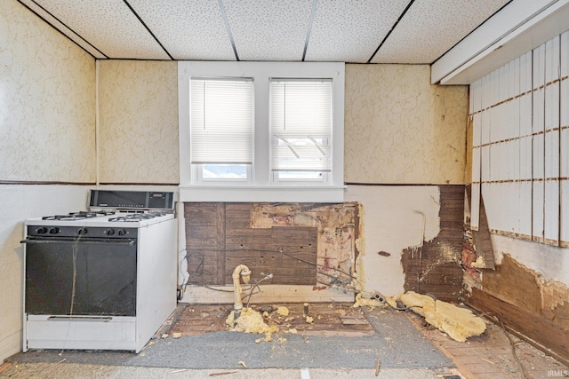 kitchen with a drop ceiling and white gas range