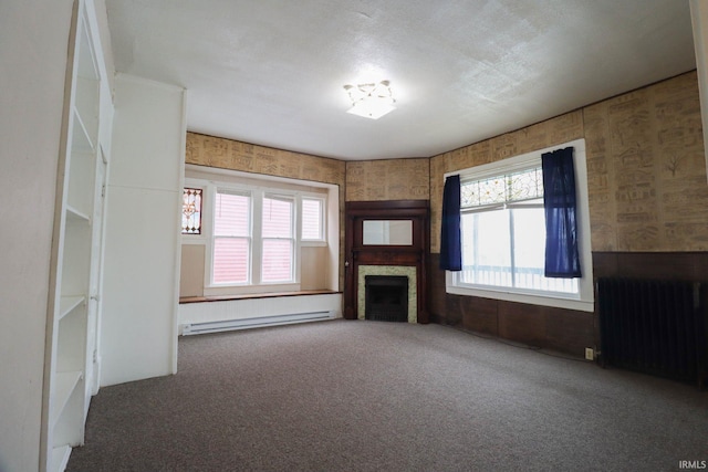 unfurnished living room featuring carpet floors, radiator, and a baseboard radiator