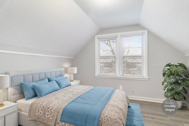 bedroom with hardwood / wood-style flooring and lofted ceiling