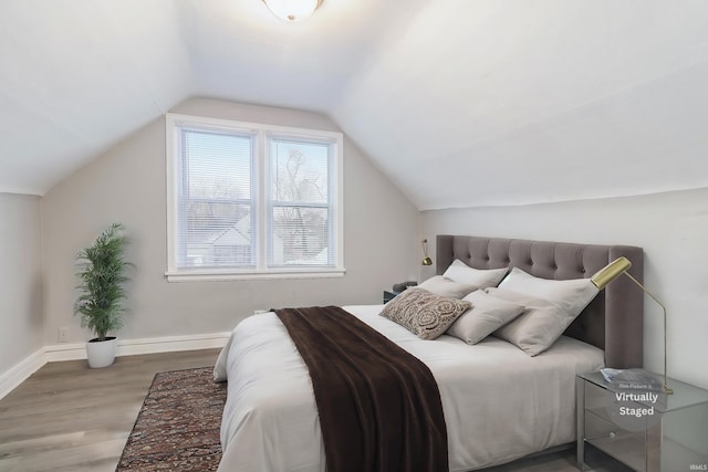 bedroom featuring wood-type flooring and lofted ceiling