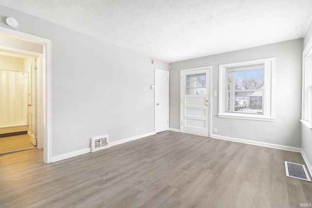 spare room with wood-type flooring and a textured ceiling