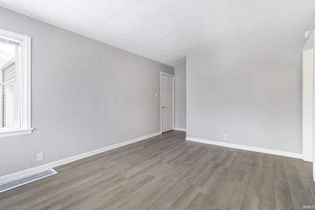 unfurnished room featuring hardwood / wood-style flooring and a textured ceiling