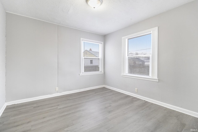 spare room featuring a textured ceiling and hardwood / wood-style flooring