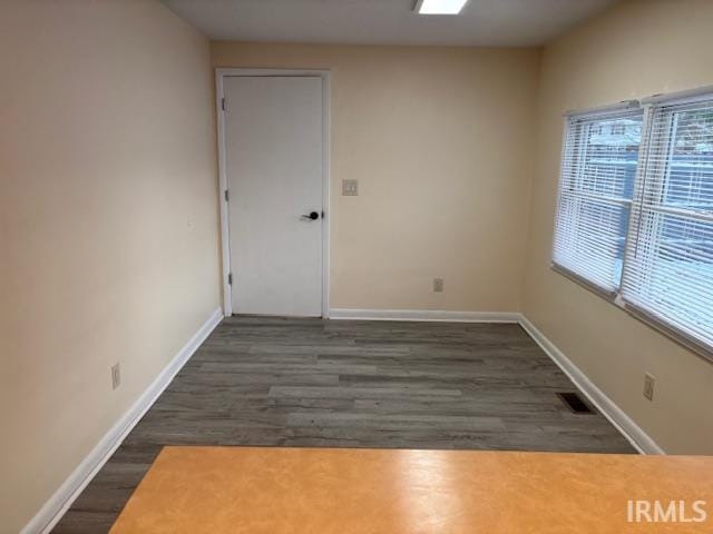 unfurnished room with dark hardwood / wood-style flooring