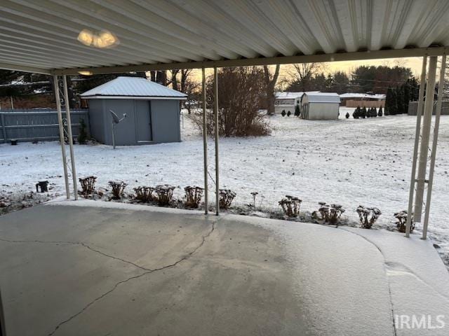 yard covered in snow with a shed