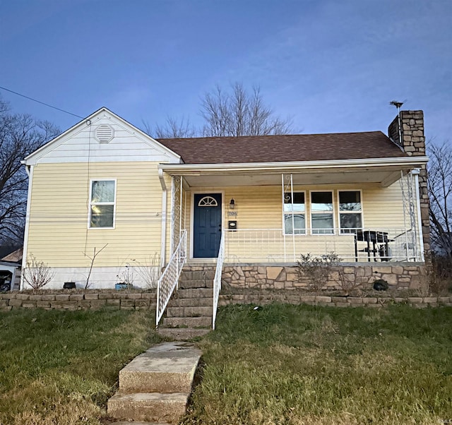 view of front of home with a porch and a front yard