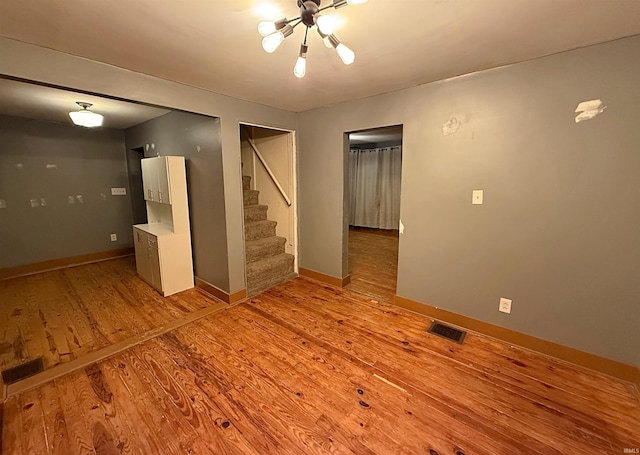 empty room featuring light hardwood / wood-style floors and an inviting chandelier