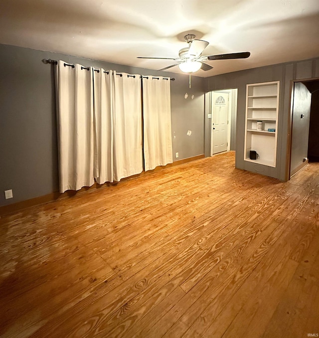 unfurnished living room featuring ceiling fan and wood-type flooring