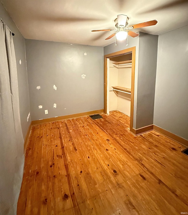 unfurnished bedroom featuring ceiling fan, light hardwood / wood-style floors, and a closet