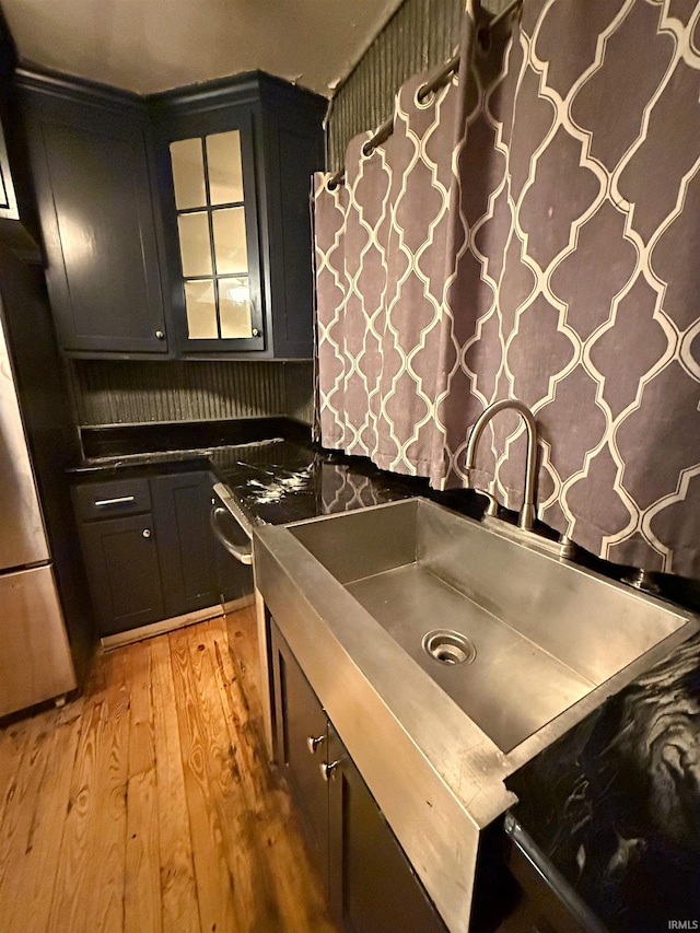 kitchen with stainless steel fridge, sink, and light hardwood / wood-style flooring