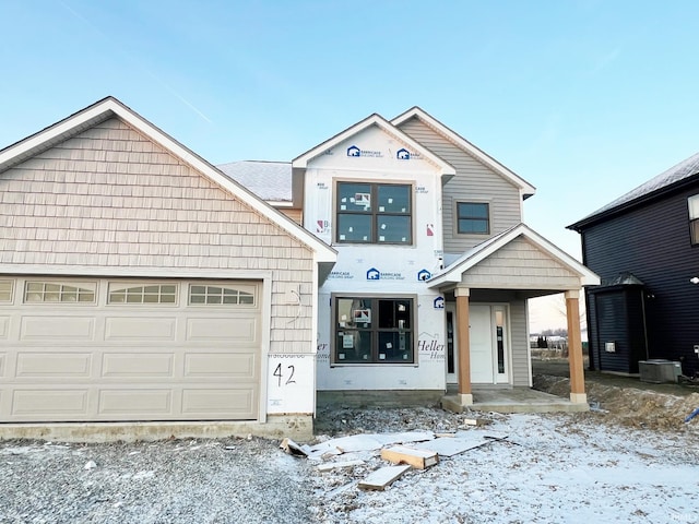 view of front of house featuring covered porch, a garage, and central air condition unit