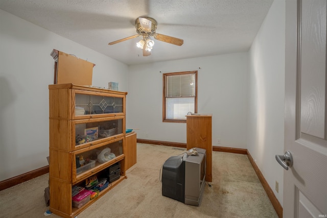 miscellaneous room with light carpet, ceiling fan, and a textured ceiling