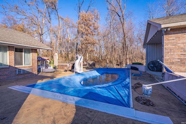 view of swimming pool featuring a jacuzzi, a patio, and a water slide