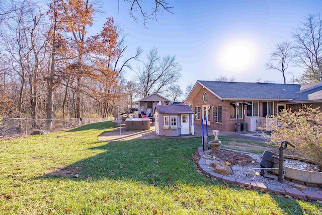 view of yard featuring a storage unit, a patio area, central air condition unit, and a hot tub