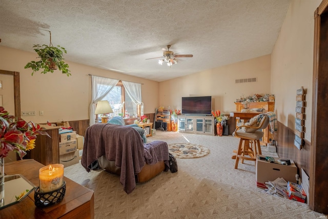 carpeted living room featuring a textured ceiling and ceiling fan