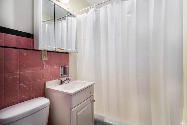 bathroom featuring a shower with curtain, toilet, decorative backsplash, vanity, and tile walls