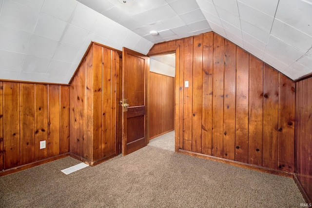 bonus room featuring wooden walls and vaulted ceiling