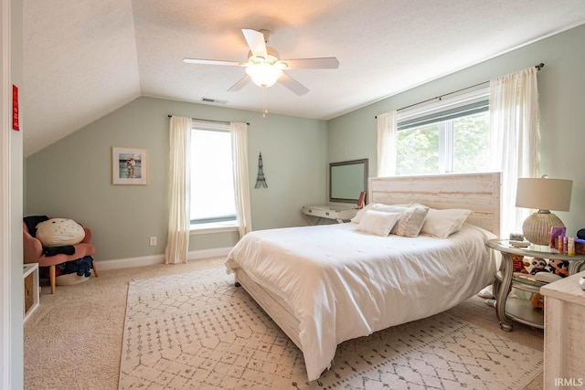 carpeted bedroom featuring ceiling fan, a textured ceiling, and vaulted ceiling