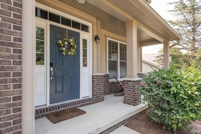 view of exterior entry featuring covered porch