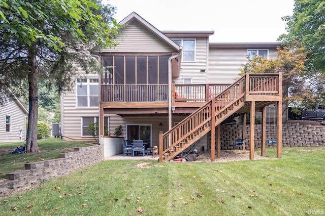 back of house featuring a sunroom, a patio area, a wooden deck, and a lawn