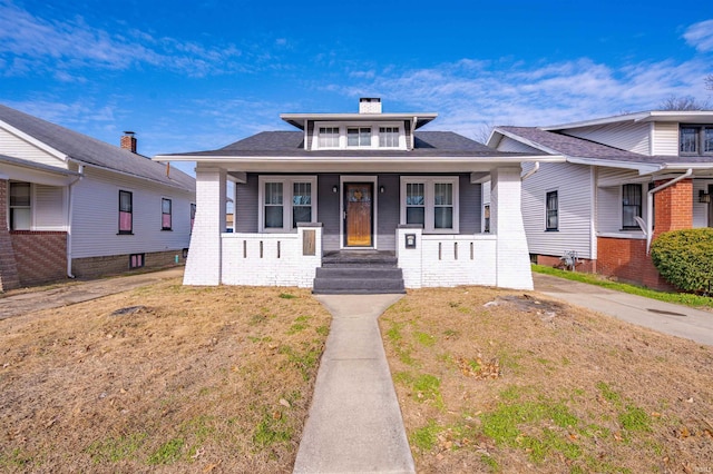 bungalow-style house featuring a front yard and covered porch