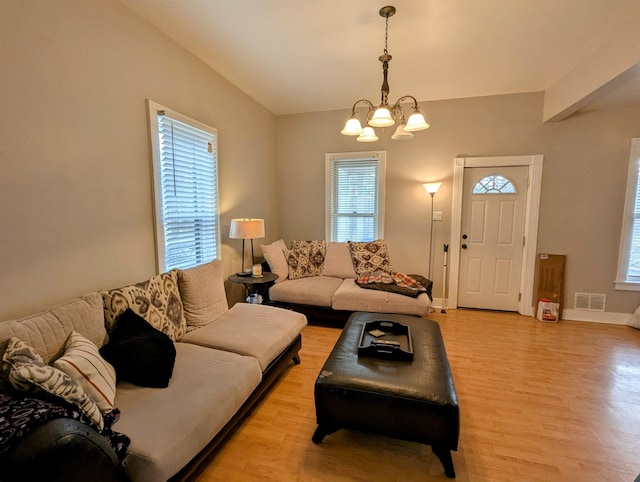 living room featuring a notable chandelier and light wood-type flooring