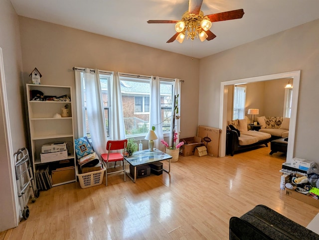 living area with wood-type flooring and ceiling fan