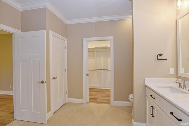 bathroom featuring tile patterned flooring, toilet, vanity, and ornamental molding