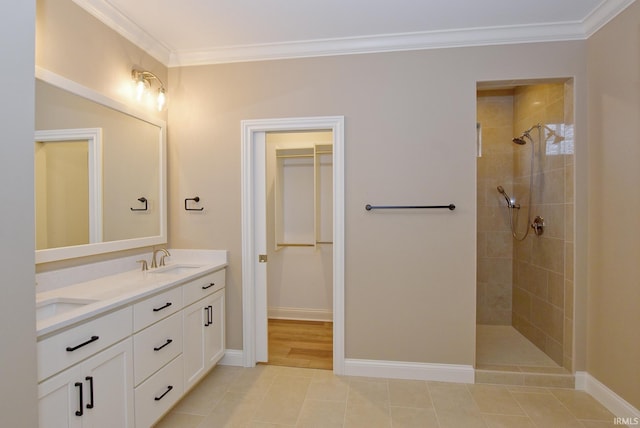 bathroom featuring crown molding, tile patterned flooring, vanity, and tiled shower