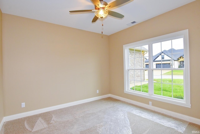 carpeted spare room with ceiling fan and a healthy amount of sunlight