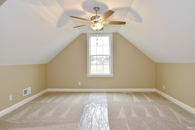 additional living space featuring light colored carpet, vaulted ceiling, and ceiling fan