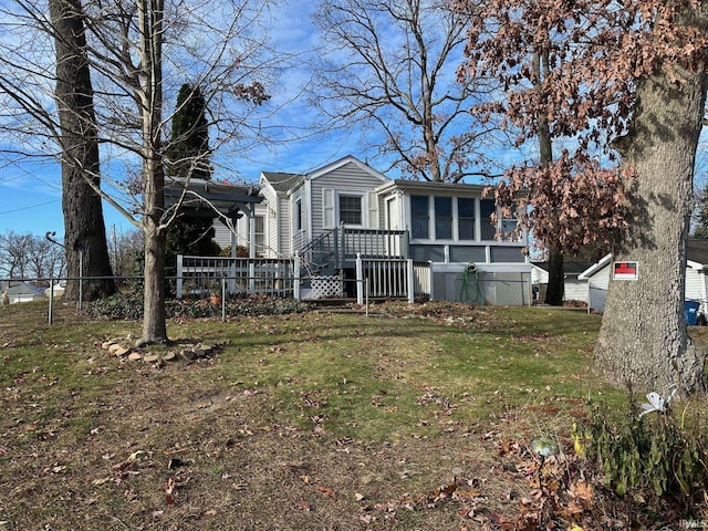 view of front facade with a sunroom and a front yard