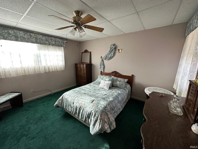 carpeted bedroom with a paneled ceiling and ceiling fan