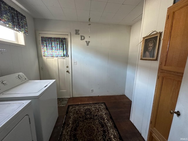 washroom with wood walls, dark hardwood / wood-style flooring, and washing machine and clothes dryer