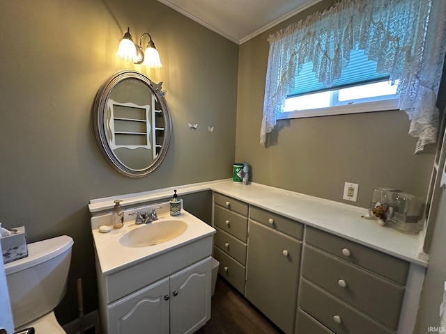 bathroom with vanity, toilet, and ornamental molding