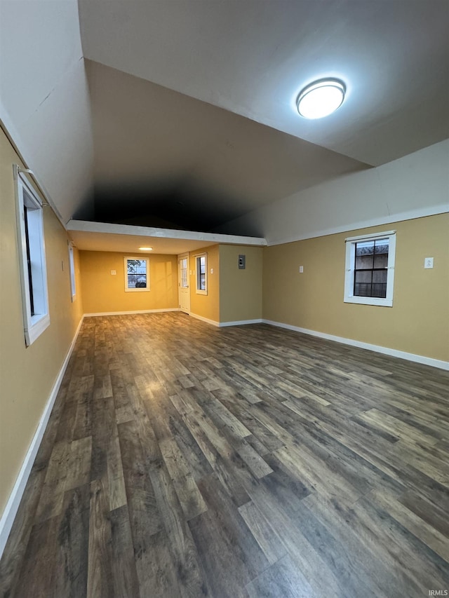 additional living space with vaulted ceiling and dark hardwood / wood-style floors