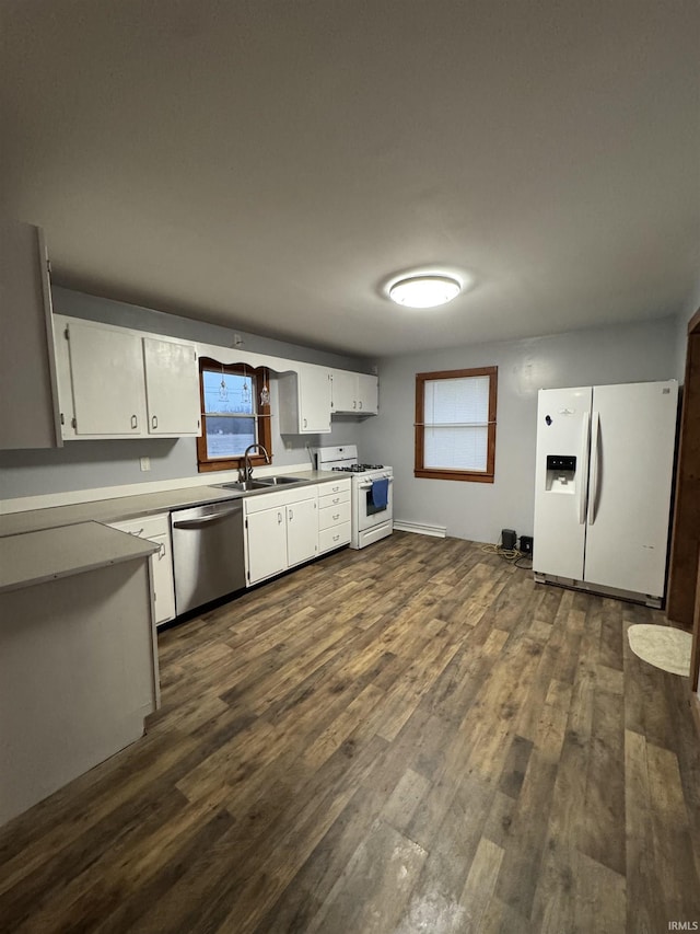 kitchen with dark wood-type flooring, a wealth of natural light, white cabinets, and white appliances