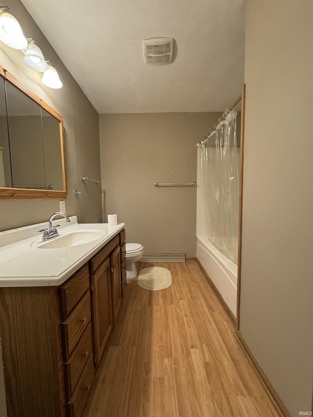 full bathroom featuring toilet, vanity, shower / bath combination with curtain, hardwood / wood-style floors, and a baseboard heating unit