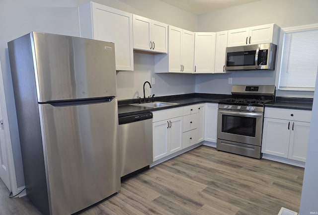 kitchen with white cabinetry, sink, hardwood / wood-style floors, and appliances with stainless steel finishes