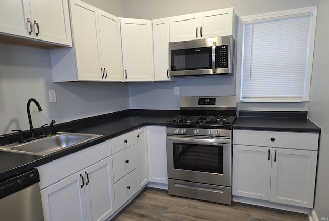 kitchen with white cabinetry, sink, dark wood-type flooring, and appliances with stainless steel finishes